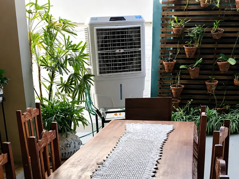 Área gourmet com mesa de madeira e climatizador da K10 ao fundo